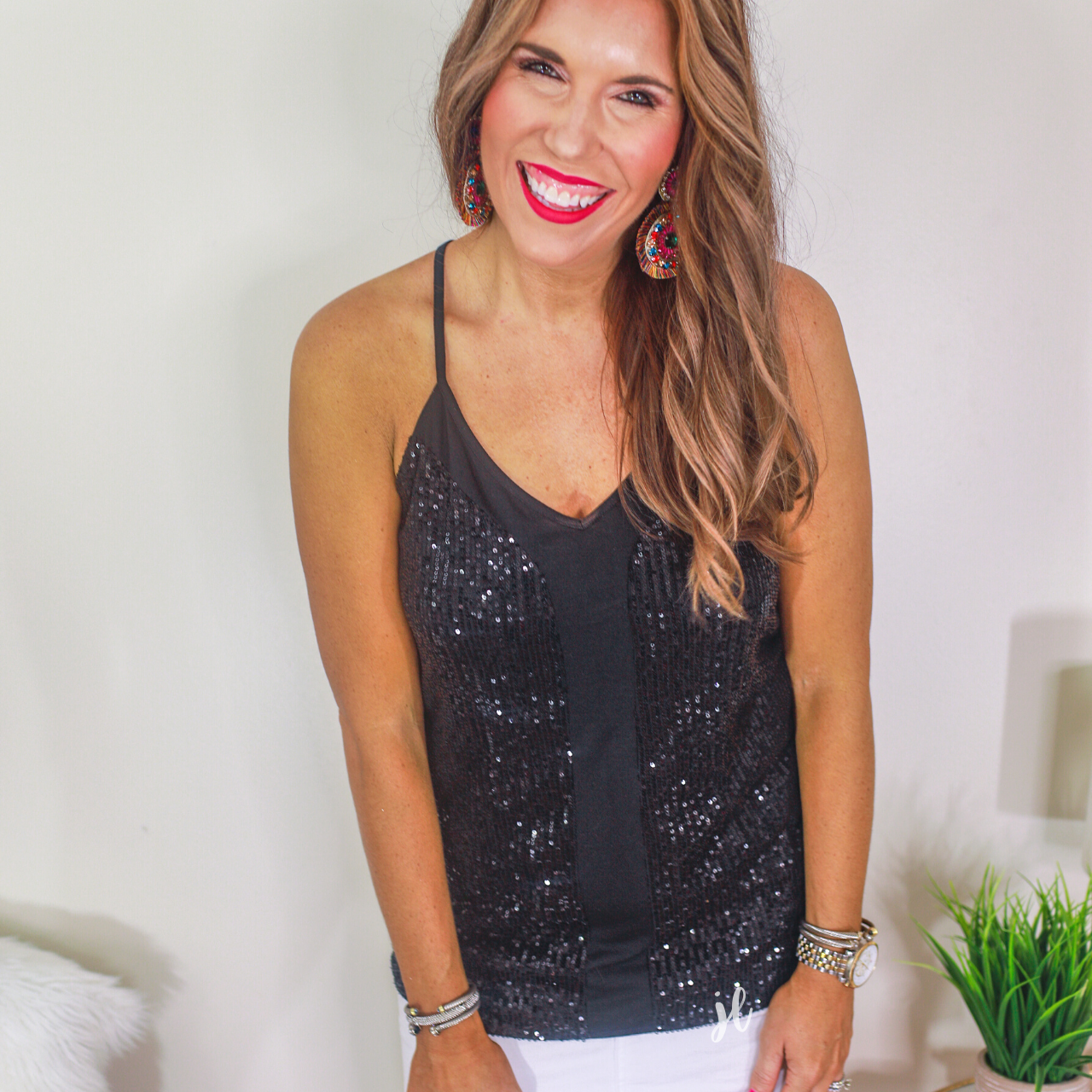 an adjustable strap racerback style sleeveless cami with a v-neckline on a sequin fabric in black