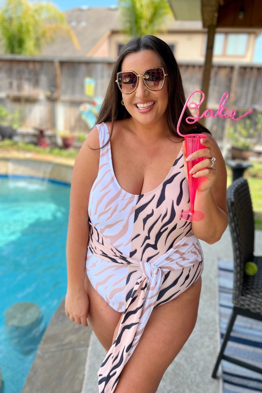 a one-piece swimsuit made of stretch swim fabric with a soft colorblock animal print, chunky straps, scoop back, removable padding, and a versatile tie that can be worn at the front or side