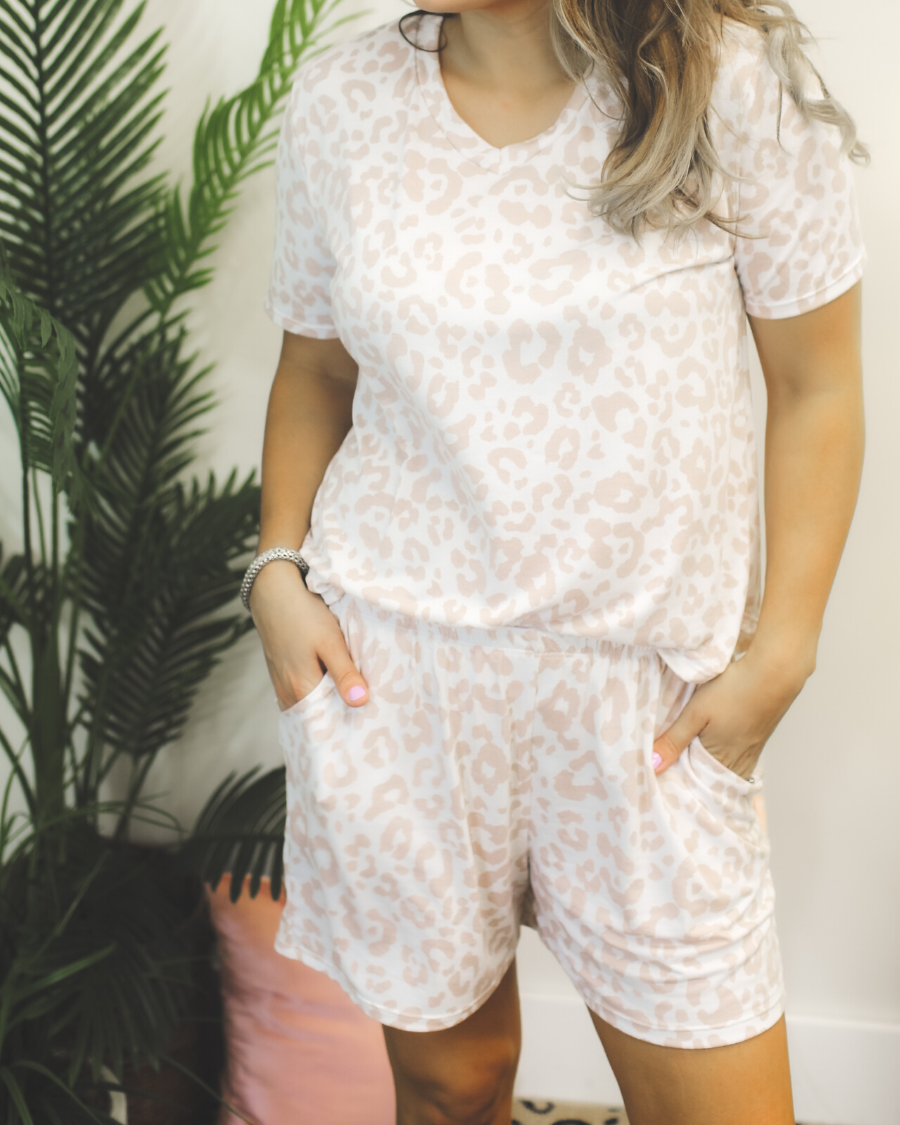 a neutral taupe animal print lounge set crafted from soft stretch fabric with a short-sleeve V-neck top, matching pull-on shorts, elastic waistband, side pockets, and relaxed fit