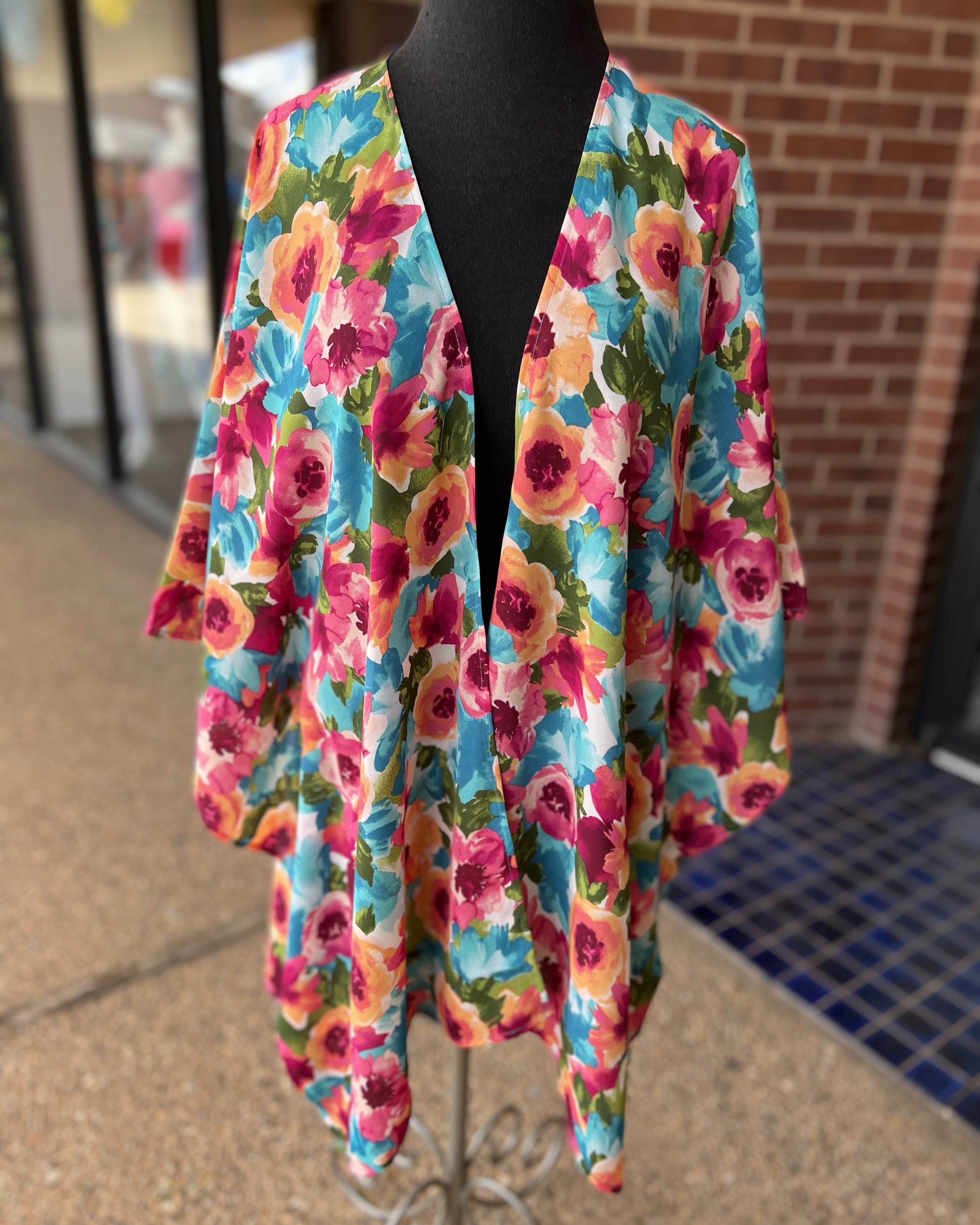 a flowy style open front kimono made of lightweight material with half sleeves on an exclusive vibrant multicolor floral pattern fabric