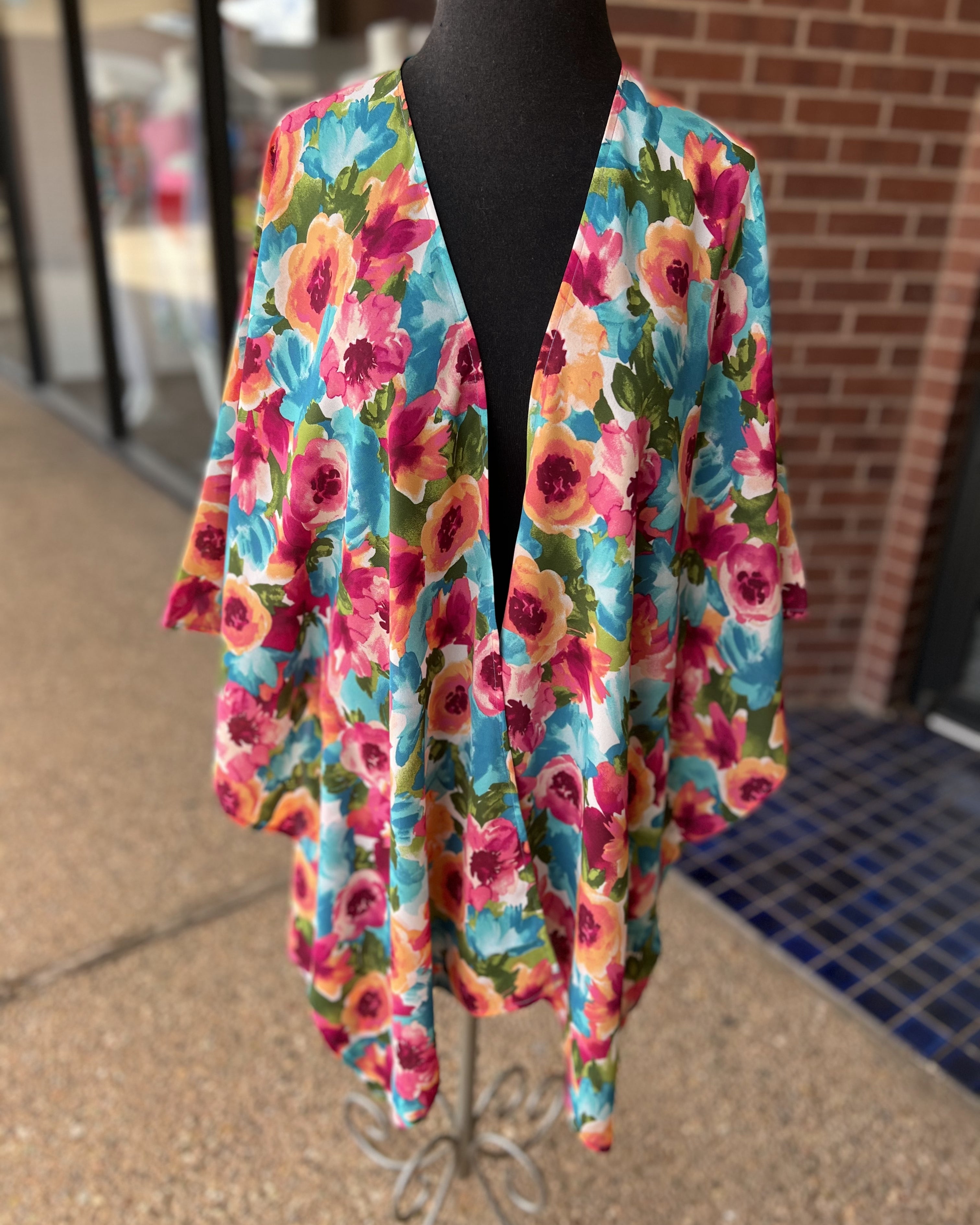 a flowy style open front kimono made of lightweight material with half sleeves on an exclusive vibrant multicolor floral pattern fabric