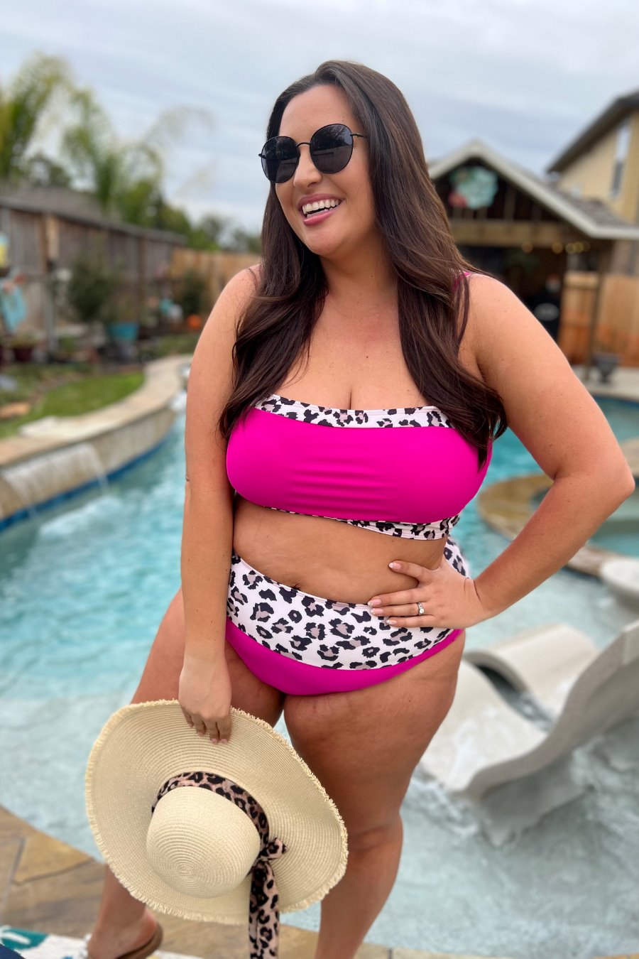 two-piece swimsuit made of stretchy material with a square neckline, adjustable spaghetti straps, and removable padding paired with high-waisted bottoms on a hot pink fabric and a leopard print trim 