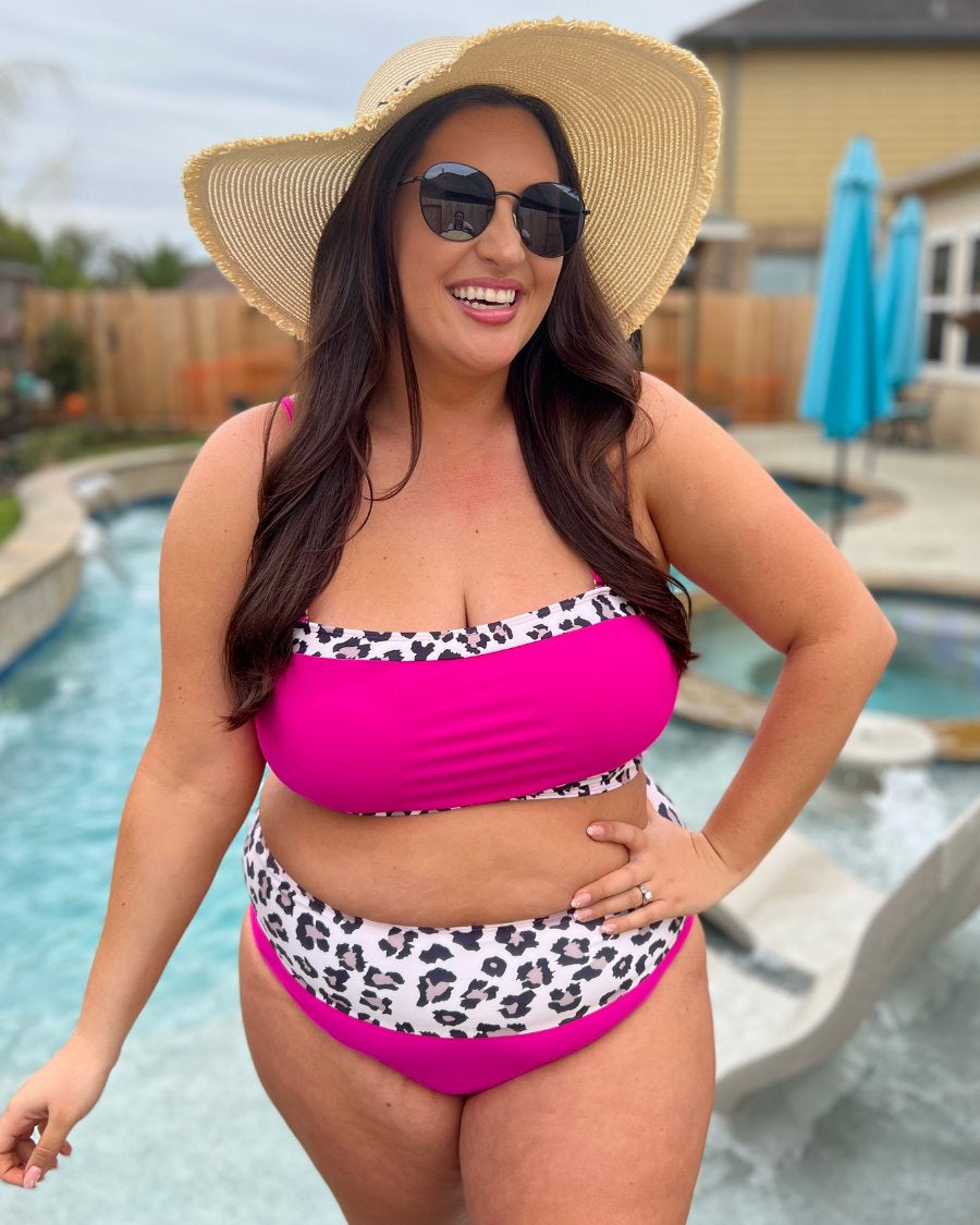 two-piece swimsuit made of stretchy material with a square neckline, adjustable spaghetti straps, and removable padding paired with high-waisted bottoms on a hot pink fabric and a leopard print trim 