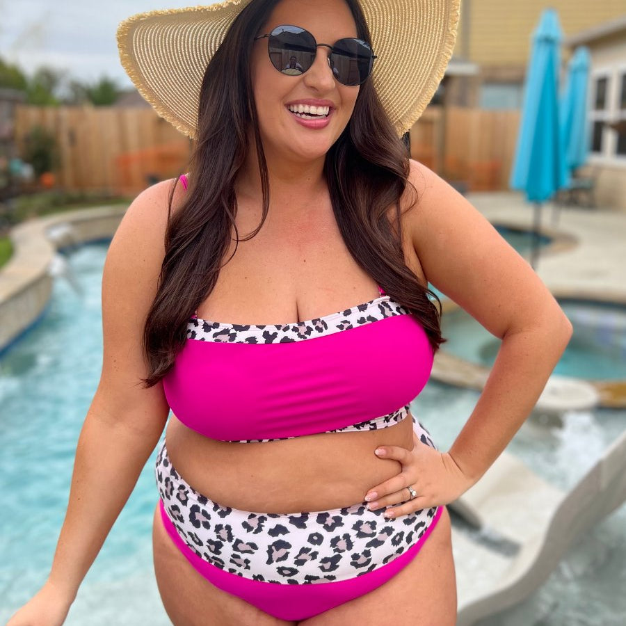 two-piece swimsuit made of stretchy material with a square neckline, adjustable spaghetti straps, and removable padding paired with high-waisted bottoms on a hot pink fabric and a leopard print trim 