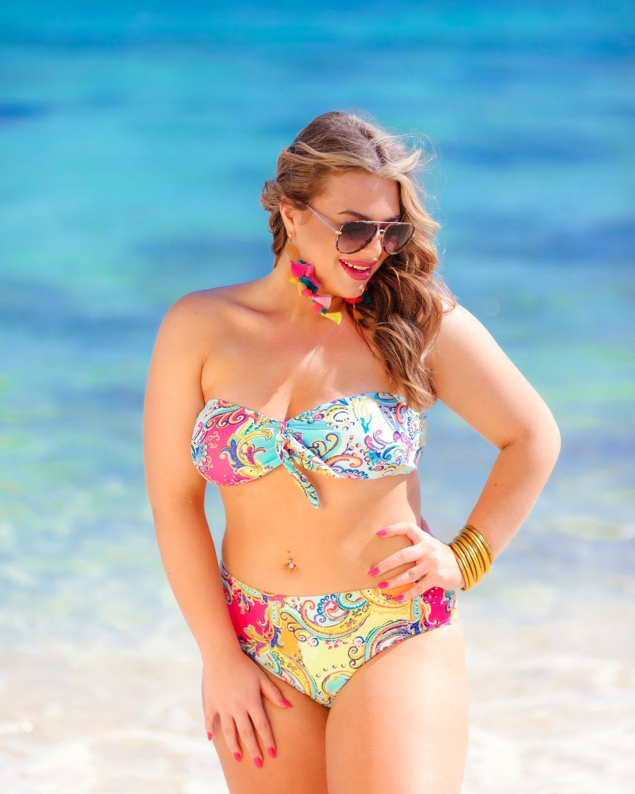 two-piece swimsuit with a sweetheart neckline bandeau top, a front tie detail, a flattering-hugging silhouette, removable padding, and a cheeky fit bottom on a multi-colored paisley print fabric