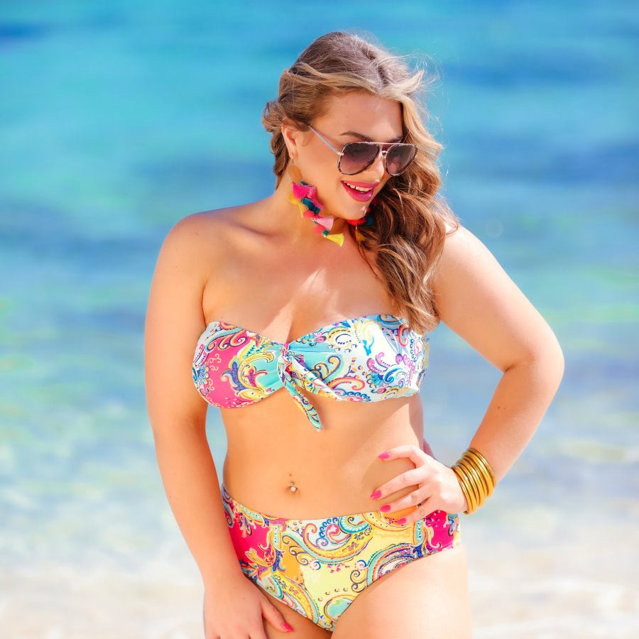 two-piece swimsuit with a sweetheart neckline bandeau top, a front tie detail, a flattering-hugging silhouette, removable padding, and a cheeky fit bottom on a multi-colored paisley print fabric