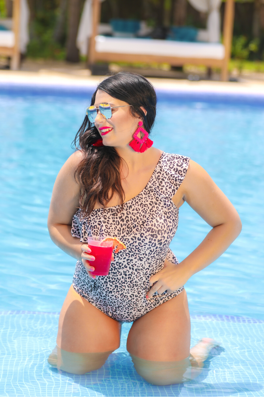 a one-piece swimsuit made from stretchy swim fabric with a black and neutral leopard print, one-shoulder ruffled neckline, and removable padding