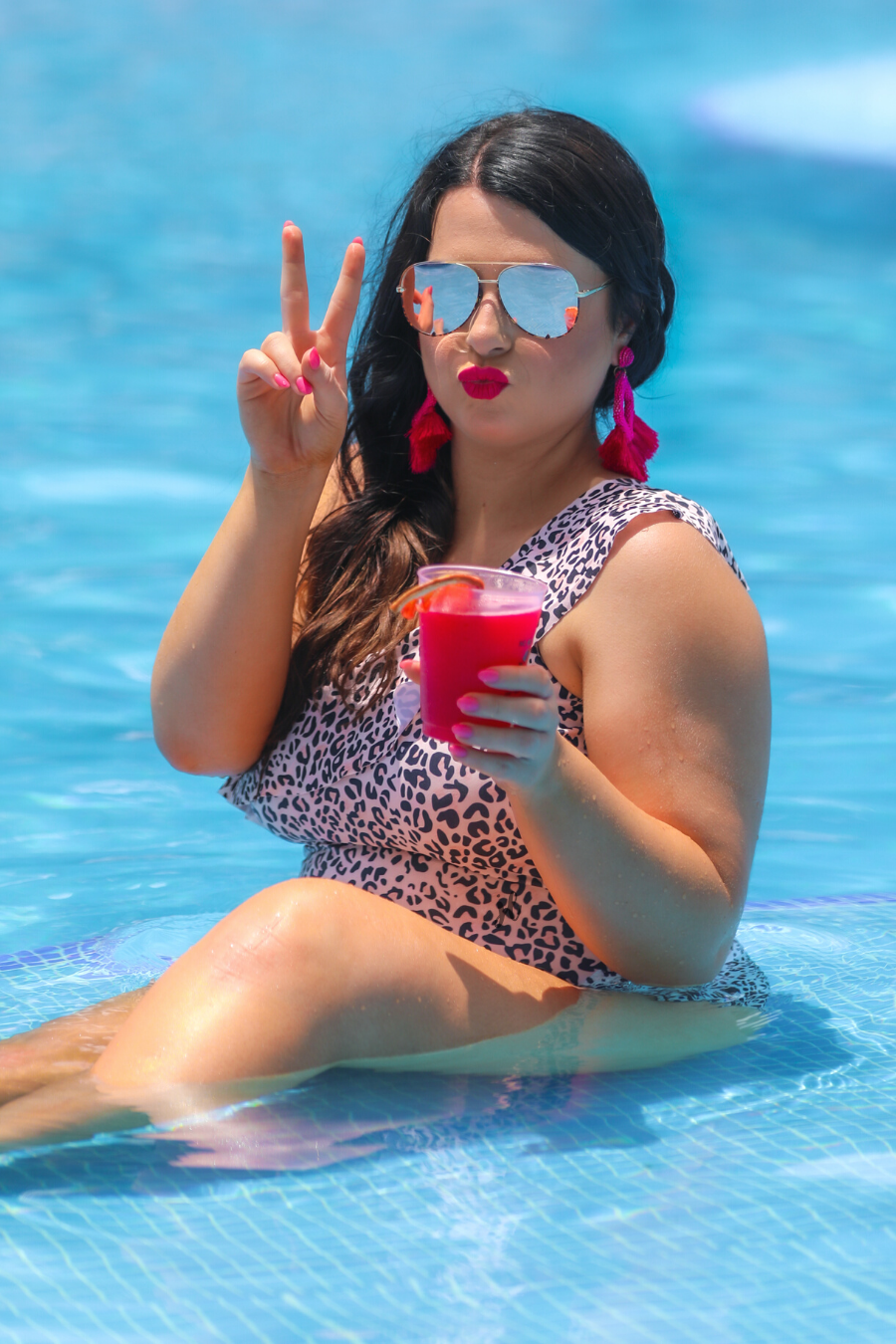 a one-piece swimsuit made from stretchy swim fabric with a black and neutral leopard print, one-shoulder ruffled neckline, and removable padding