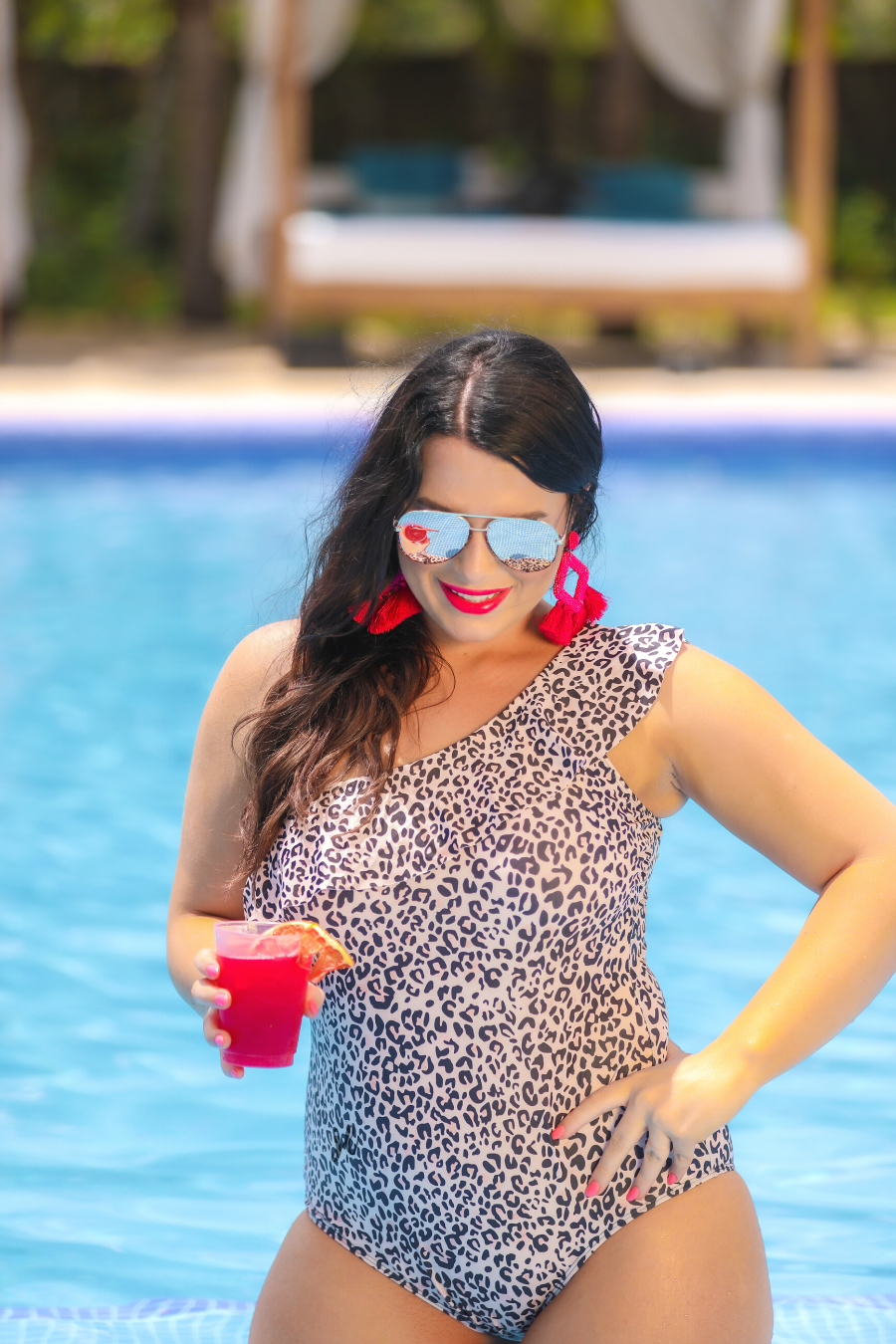 a one-piece swimsuit made from stretchy swim fabric with a black and neutral leopard print, one-shoulder ruffled neckline, and removable padding