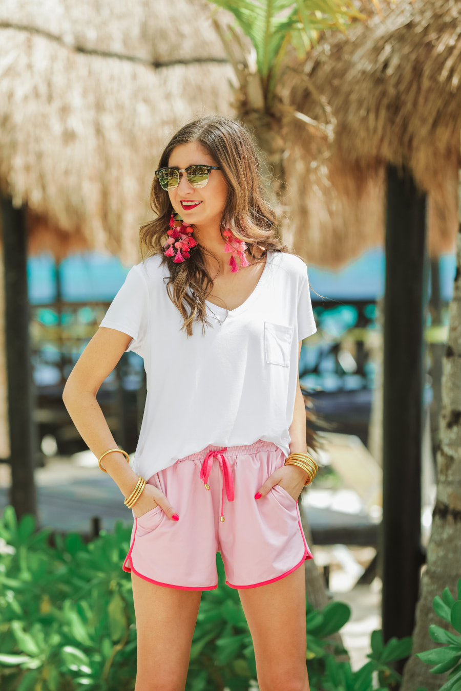 mid-rise relaxed fit activewear shorts with side pockets and a tie waist drawstring with gold bead accents, designed on a solid light print fabric and hot pink trim