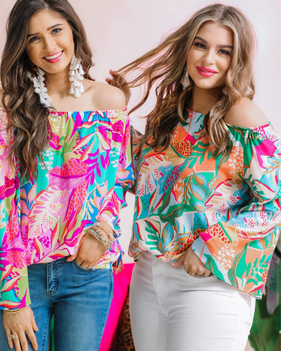 off-the-shoulder flowy top with an elastic neckline in a vibrant floral pattern in fuchsia and ivory