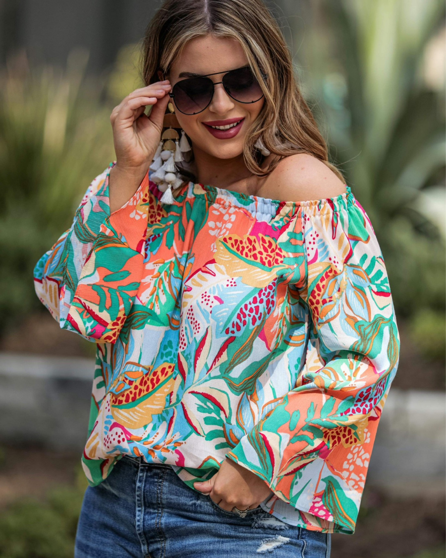 off-the-shoulder flowy top with an elastic neckline in a vibrant floral pattern in ivory
