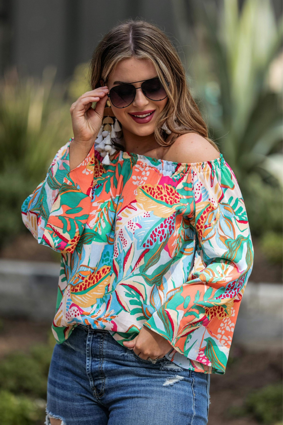 off-the-shoulder flowy top with an elastic neckline in a vibrant floral pattern in ivory