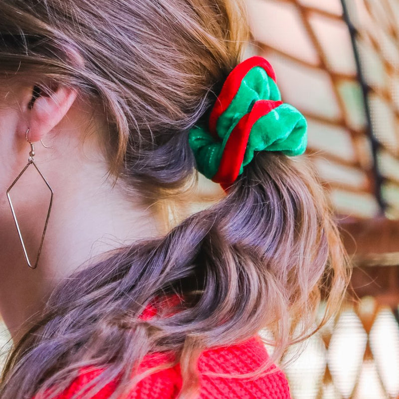 a plush velvet scrunchie in a rich nostalgic colorway (classic green with red trim) with contrasting trim and comfortable elastic