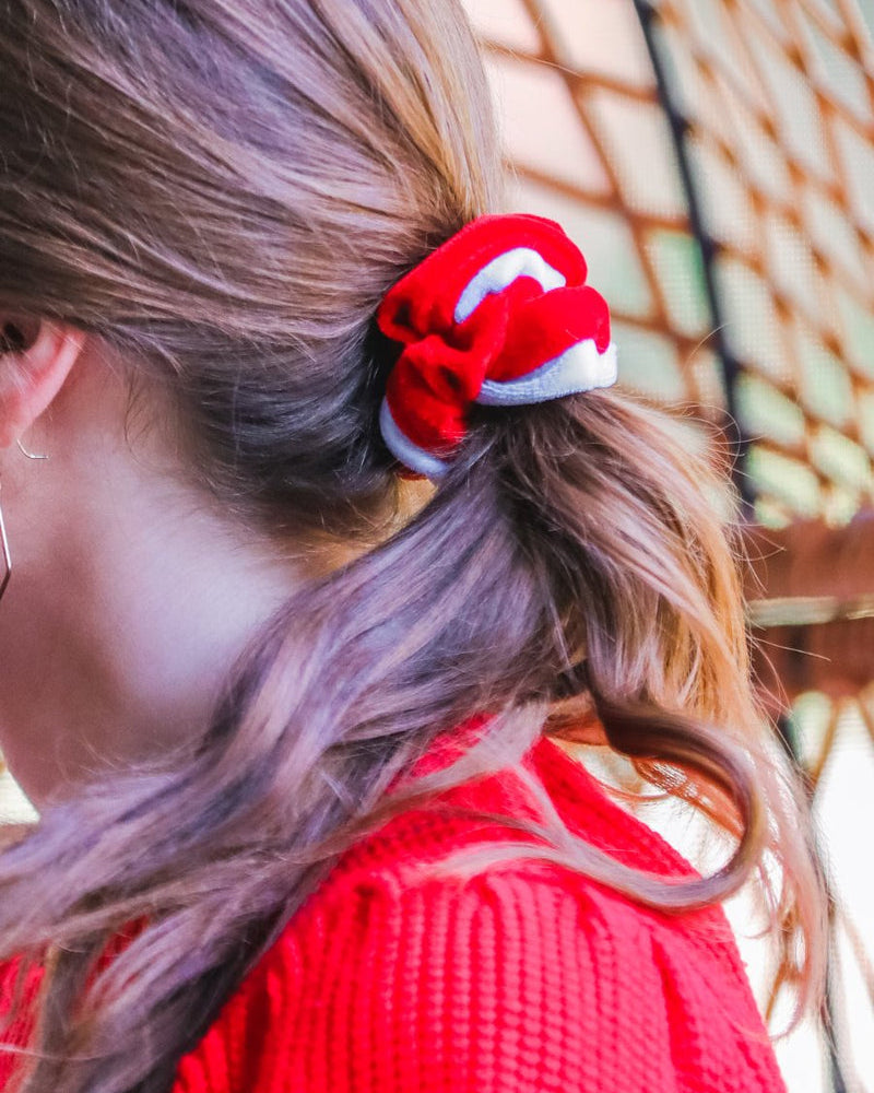 a plush velvet scrunchie in a rich nostalgic colorway (bold red with white trim) with contrasting trim and comfortable elastic
