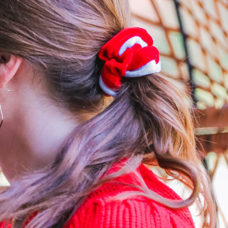 a plush velvet scrunchie in a rich nostalgic colorway (bold red with white trim) with contrasting trim and comfortable elastic