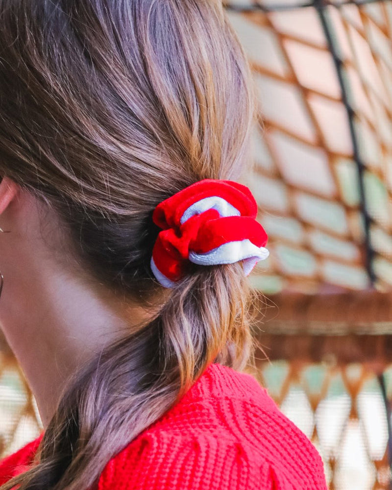 a plush velvet scrunchie in a rich nostalgic colorway (bold red with white trim) with contrasting trim and comfortable elastic