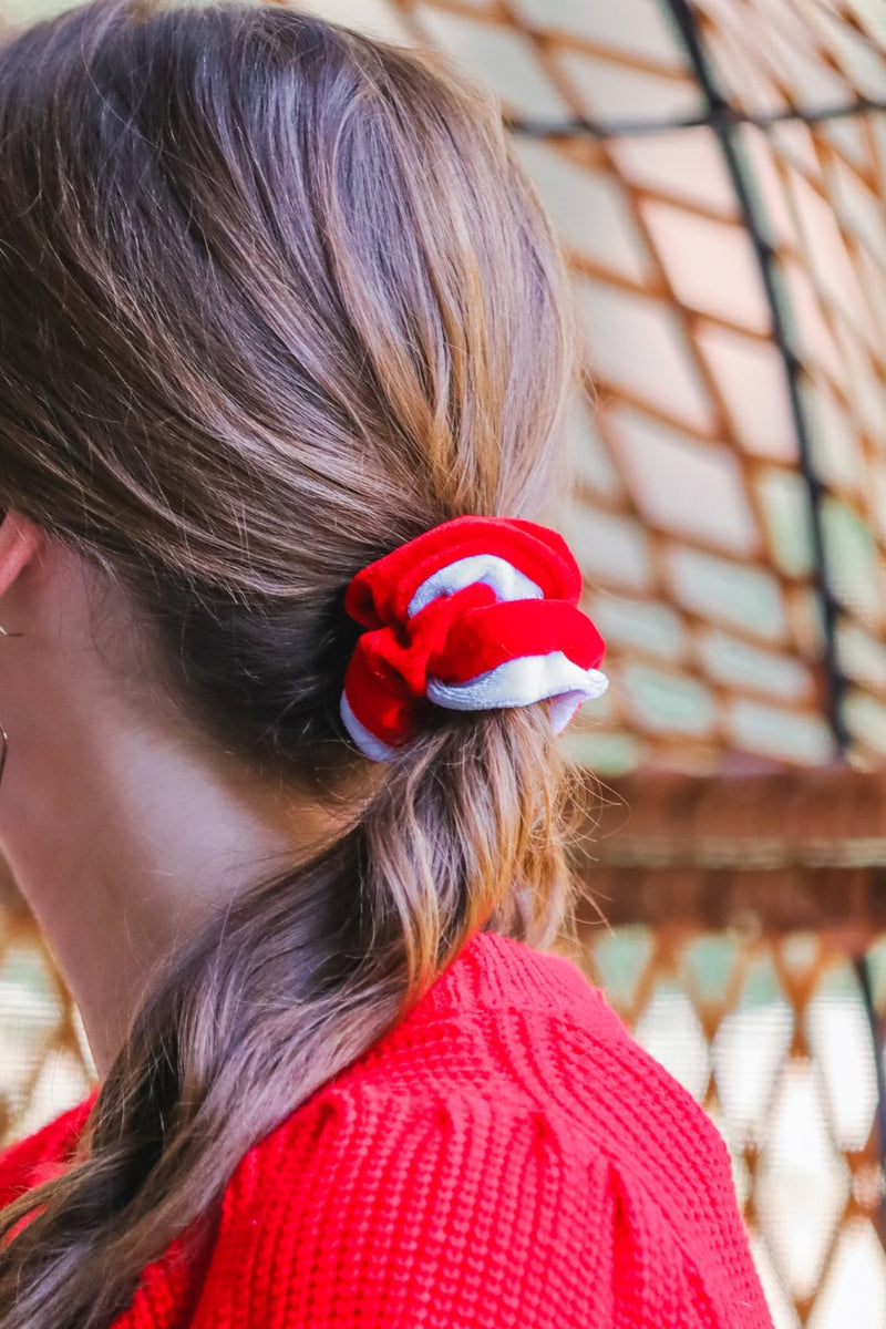 a plush velvet scrunchie in a rich nostalgic colorway (bold red with white trim) with contrasting trim and comfortable elastic