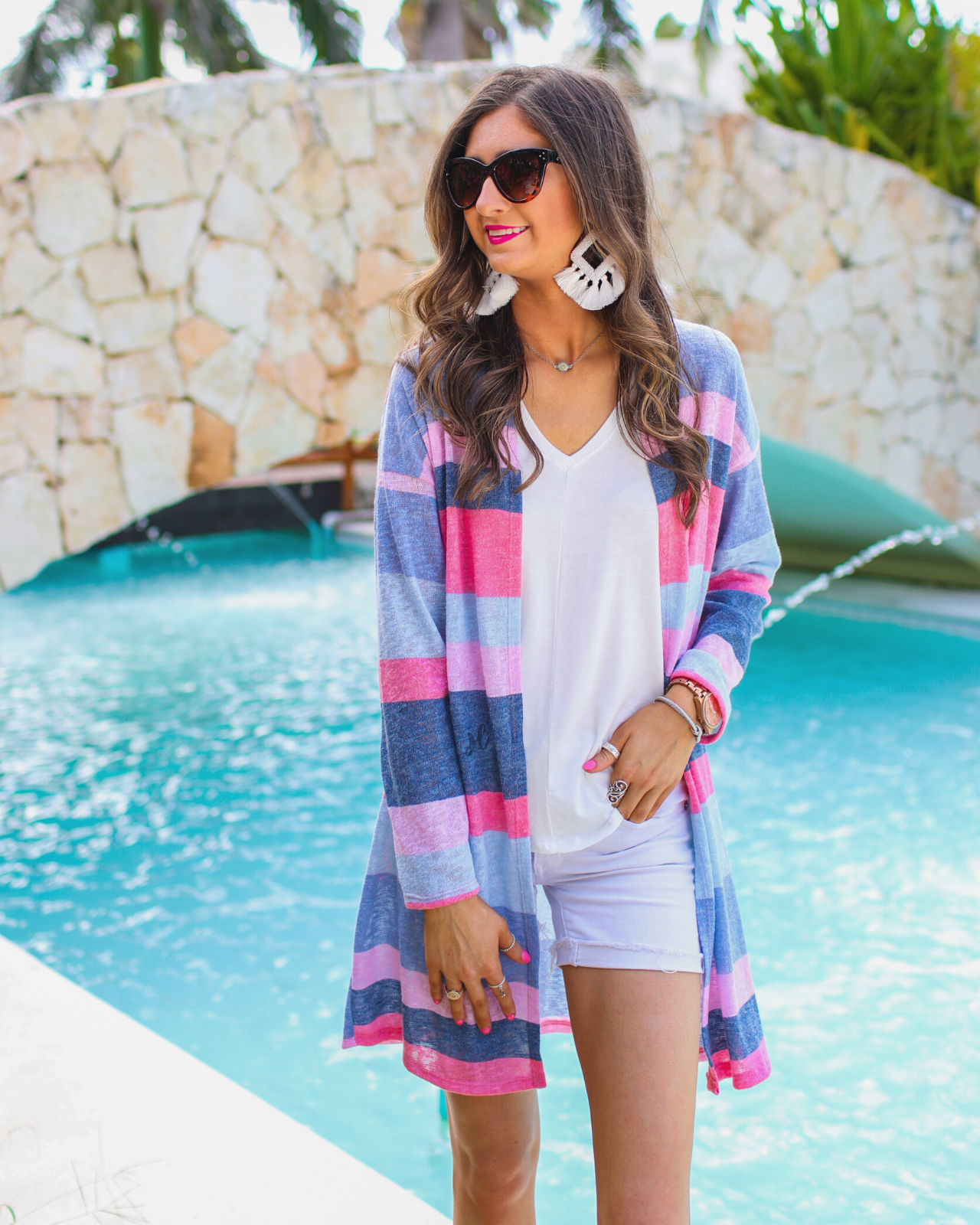 a blue long-sleeve open-front cardigan with a modern drop-shoulder silhouette, bold blue and pink horizontal stripes, and a lightweight relaxed fit