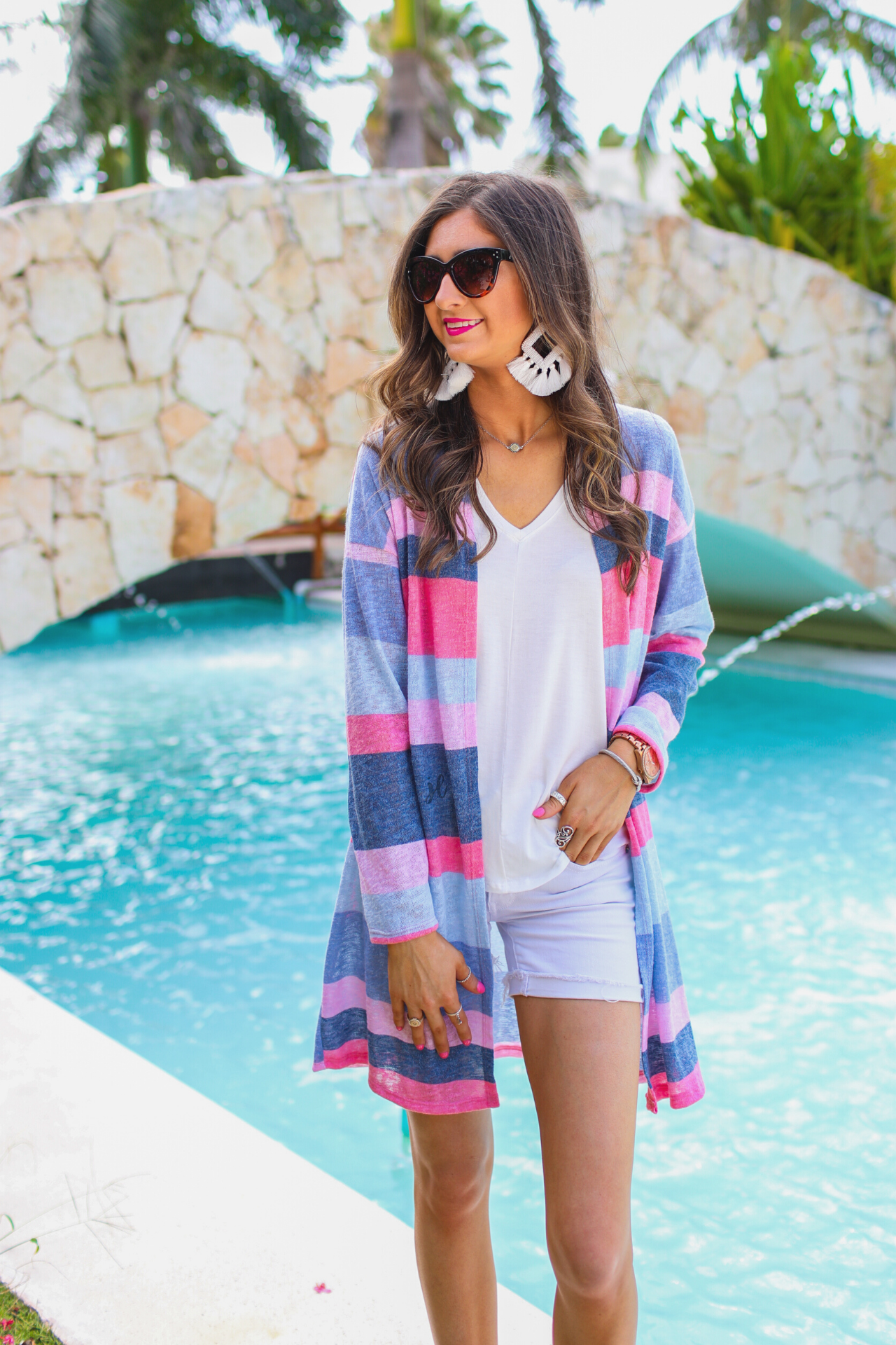 a blue long-sleeve open-front cardigan with a modern drop-shoulder silhouette, bold blue and pink horizontal stripes, and a lightweight relaxed fit