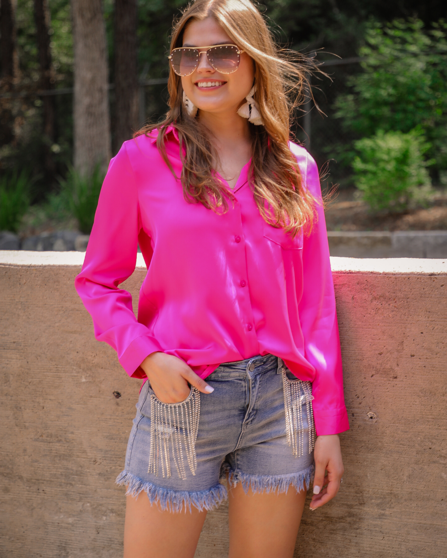 mid-rise denim shorts with rhinestone fringe, a frayed hem, full classic pockets, button zip fly with belt loops, distressed detailing, and a medium wash