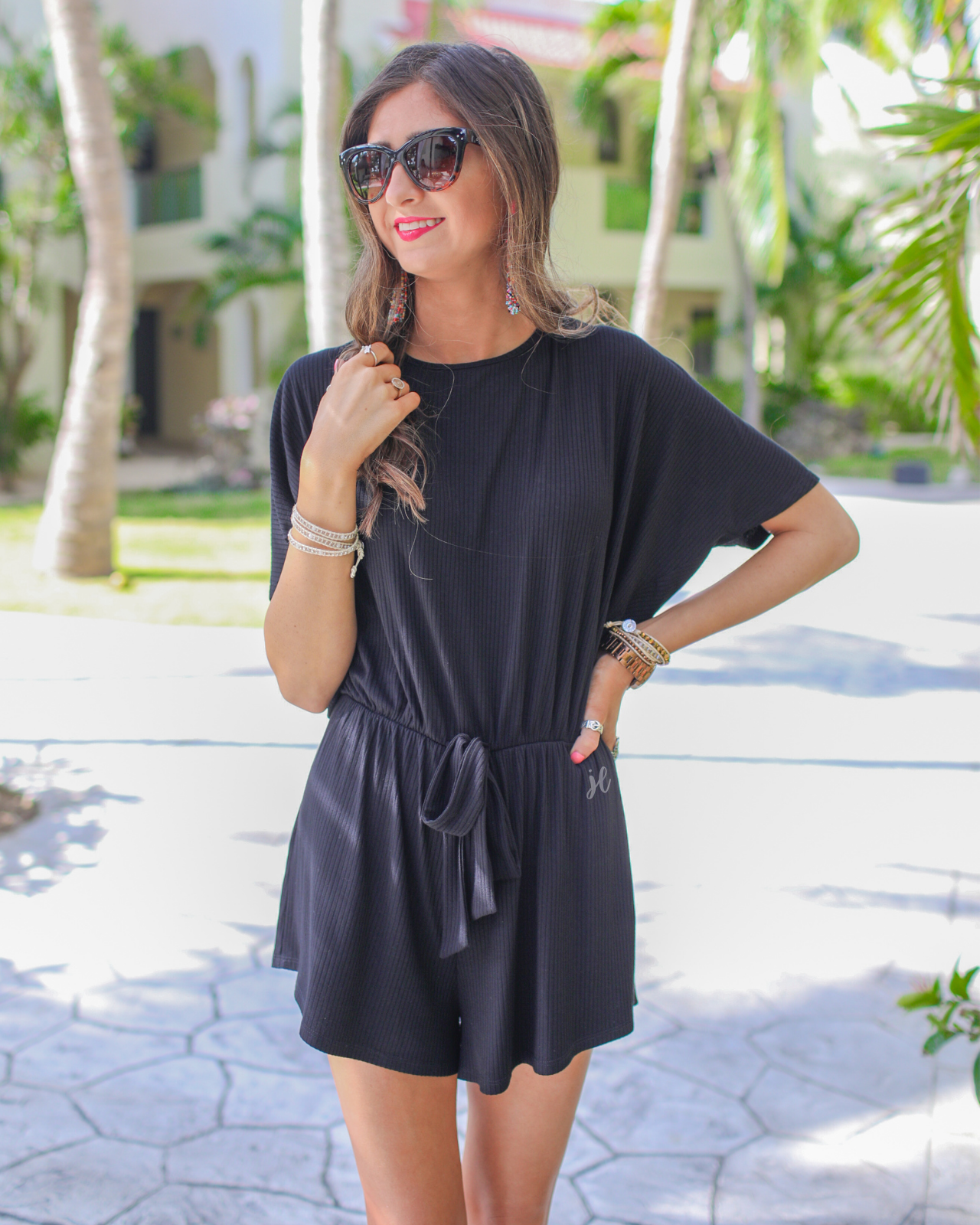 short-sleeve ribbed romper with a scoop neckline, a cutout tie back, an elastic faux tie waist, and no pockets in black
