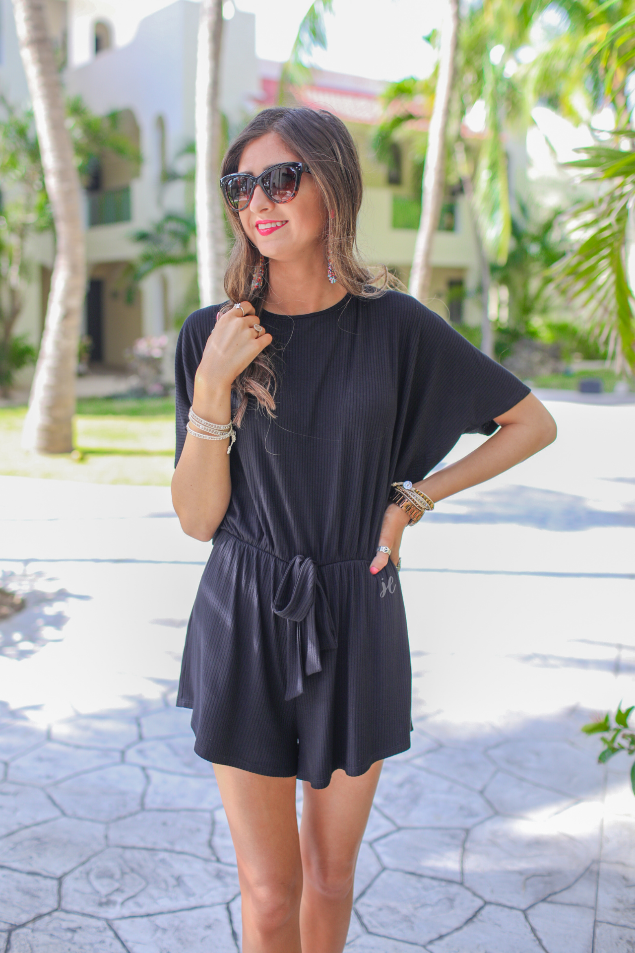 short-sleeve ribbed romper with a scoop neckline, a cutout tie back, an elastic faux tie waist, and no pockets in black