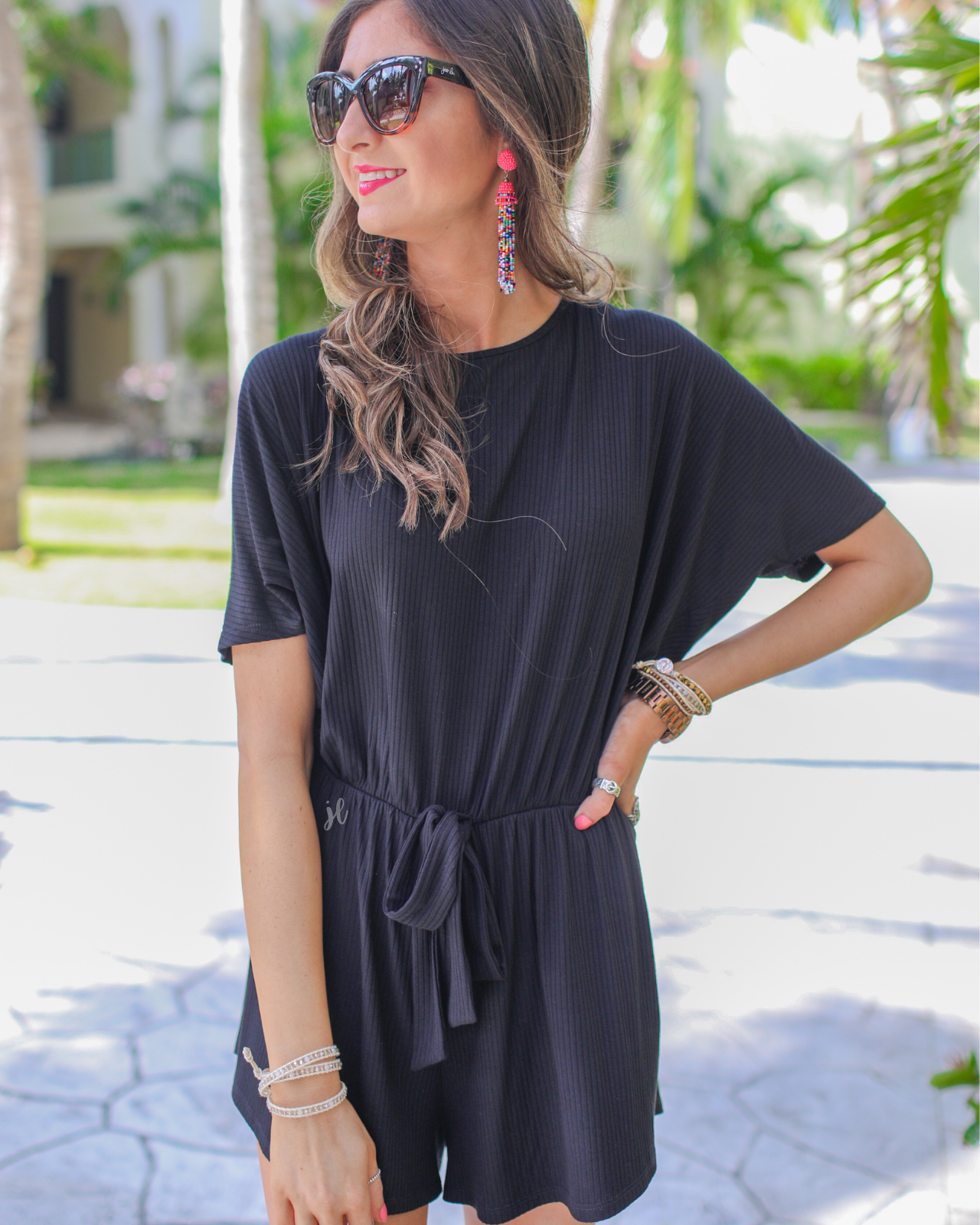 short-sleeve ribbed romper with a scoop neckline, a cutout tie back, an elastic faux tie waist, and no pockets in black