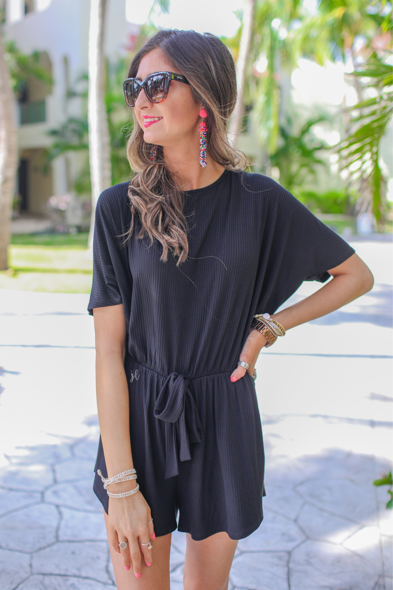 short-sleeve ribbed romper with a scoop neckline, a cutout tie back, an elastic faux tie waist, and no pockets in black