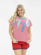 a high-stretch oversized short-sleeve stripe top with a crew neckline, a horizontal stripe pattern (red and white), bold denim 1776 patch detail, tiny star accents, a relaxed easy drape, and unlined