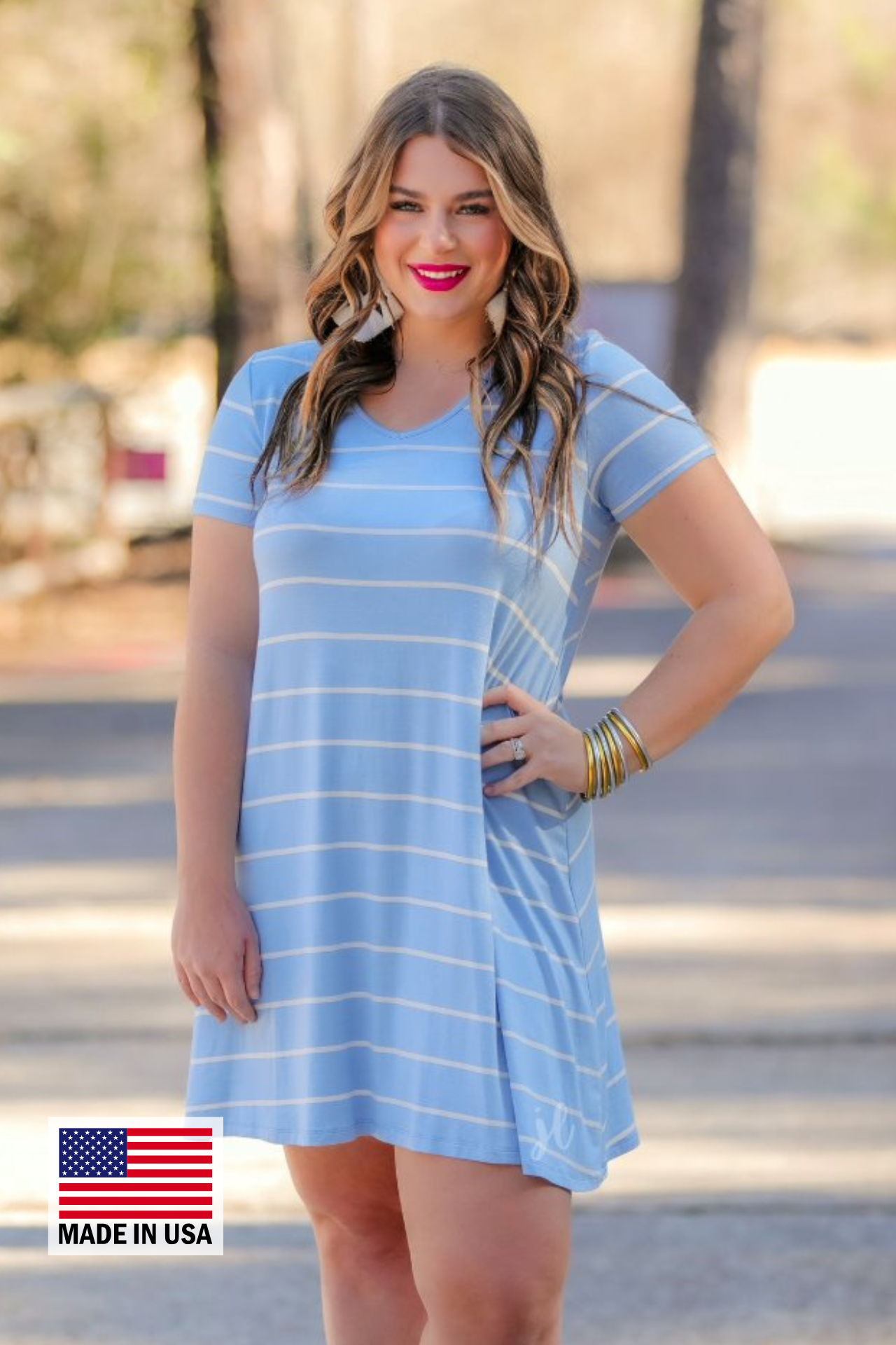 a soft stretchy knit dress with a V-neckline, short sleeves, a relaxed A-line silhouette, a straight hemline, and a horizontal white stripe pattern on a solid chambray background with a MADE IN USA watermark in the bottom left hand corner