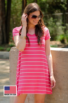 a soft stretchy knit dress with a V-neckline, short sleeves, a relaxed A-line silhouette, a straight hemline, and a horizontal white stripe pattern on a solid salmon background with a MADE IN USA watermark in the bottom left hand corner