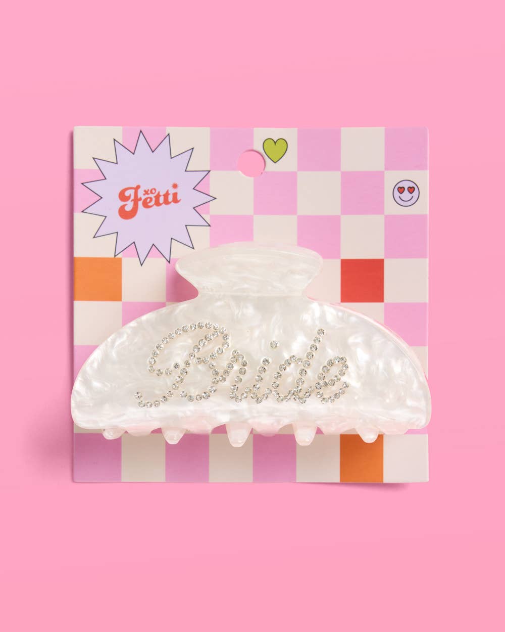 Decorative 'Bride' hair clip on a checkered box against a pink background