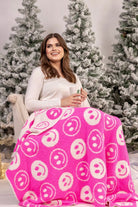 ultra-soft reversible throw on a pink and white happy face pattern print fabric in pink