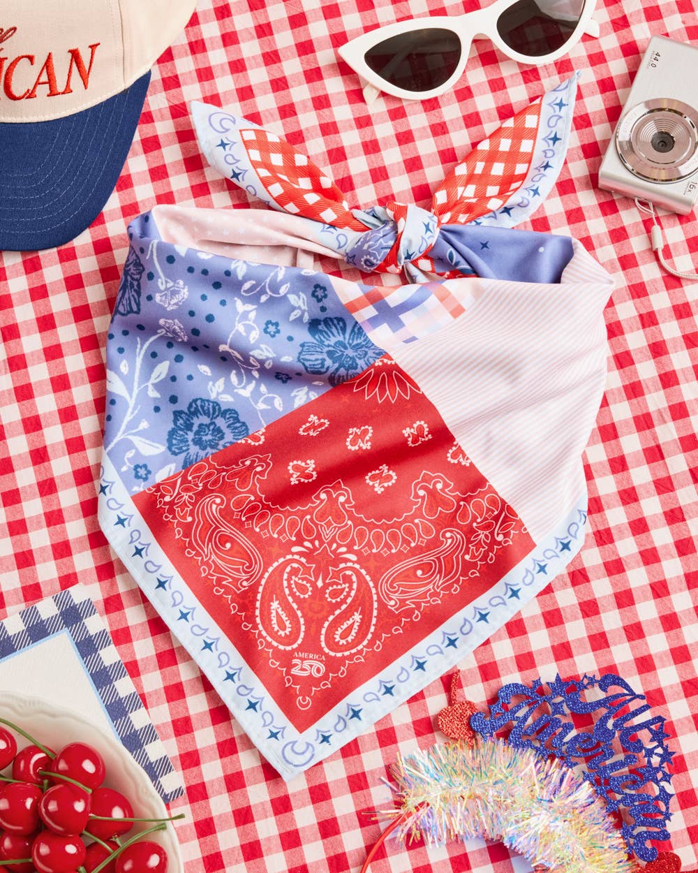 a soft silky polyester scarf with a red, white, and blue quilt-inspired print, finished with a blend of floral, gingham, and paisley details