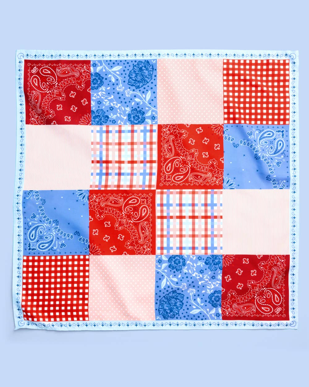 a soft silky polyester scarf with a red, white, and blue quilt-inspired print, finished with a blend of floral, gingham, and paisley details