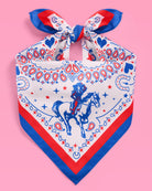 a square bandana with a red, white, and blue western-inspired print, complete with a bold border, cowgirls, hearts, horses, horseshoes, paisley accents, and stars