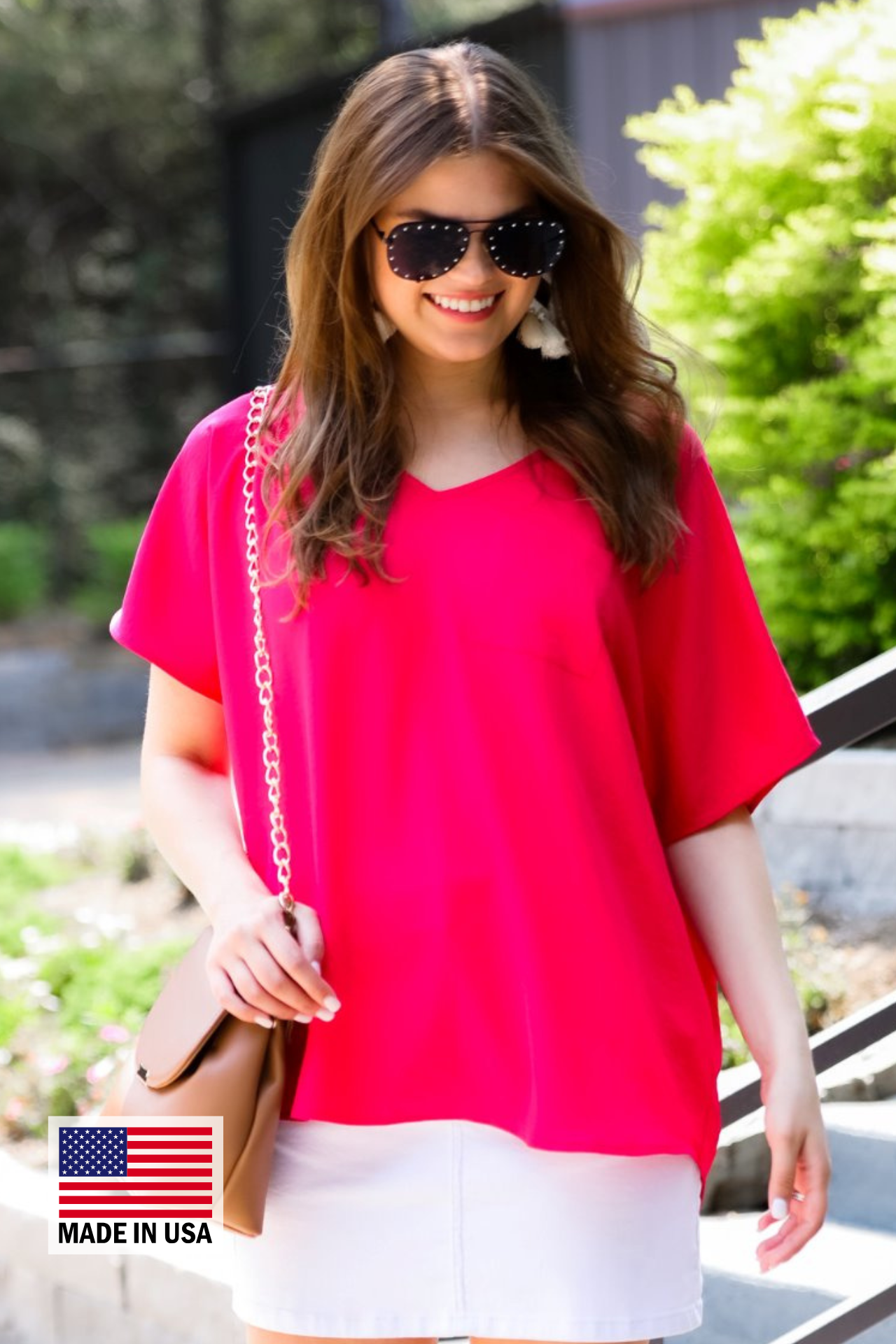 a lightweight magenta short-sleeve woven tunic with a V-neckline, a front chest pocket, and a relaxed, non-stretch silhouette, accented with a MADE IN USA watermark in the bottom left-hand corner 