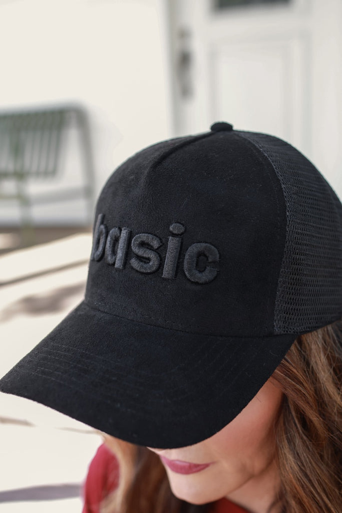 soft suede trucker hat accented with black puff embroidery of the word BASIC in lowercase letters