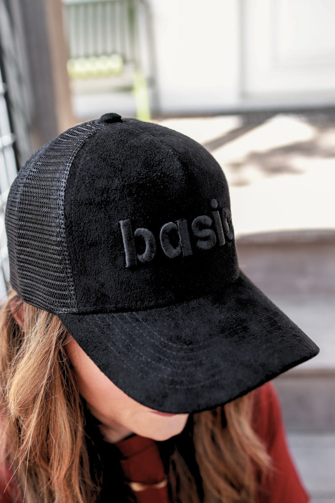 soft suede trucker hat accented with black puff embroidery of the word BASIC in lowercase letters