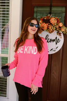 pink long-sleeve sweater made of blanket material with the wording "BE KIND" written in white