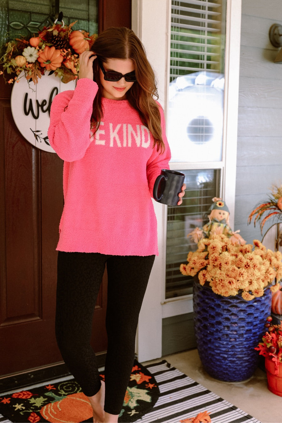 pink long-sleeve sweater made of blanket material with the wording "BE KIND" written in white