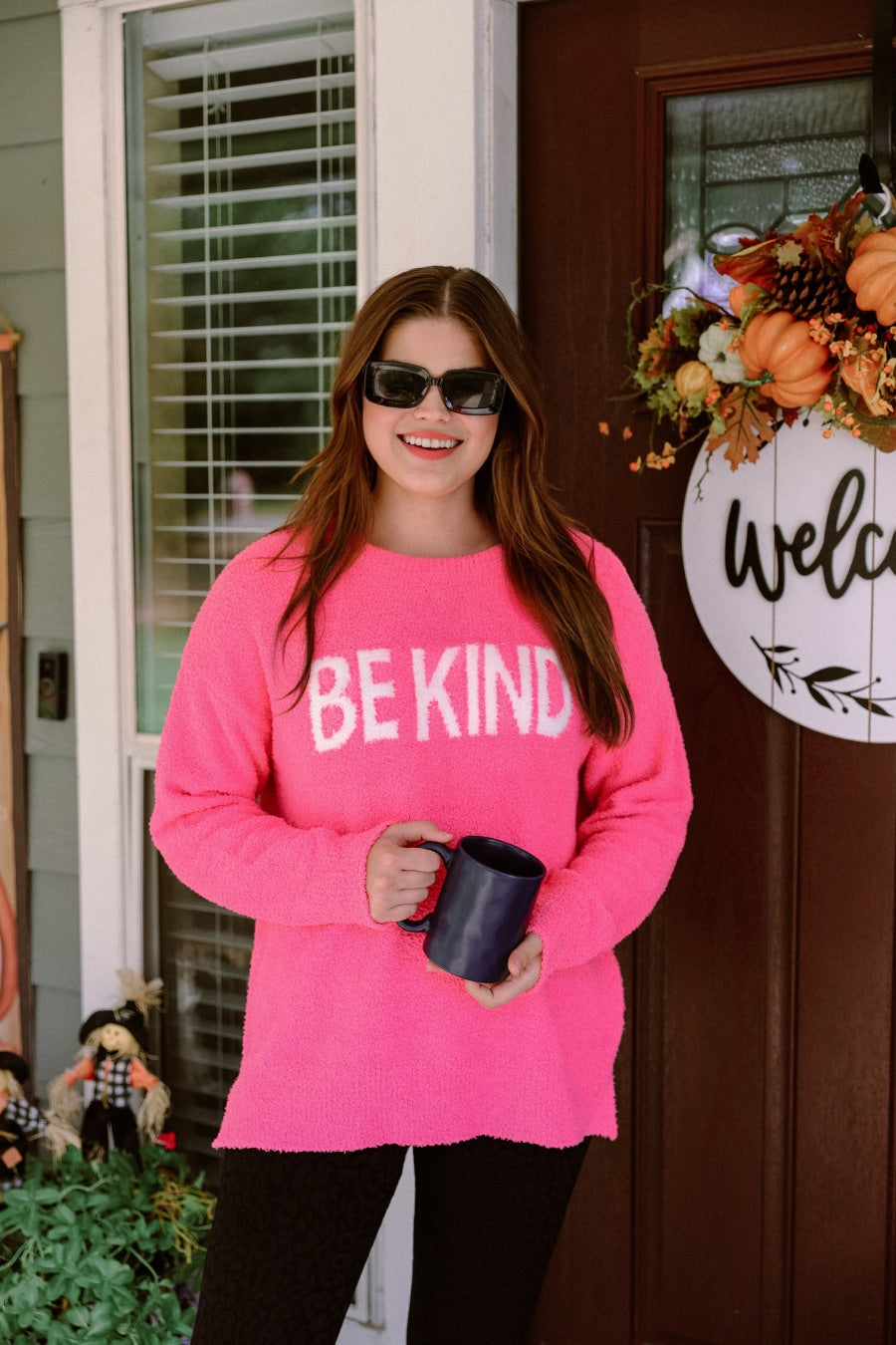 pink long-sleeve sweater made of blanket material with the wording "BE KIND" written in white