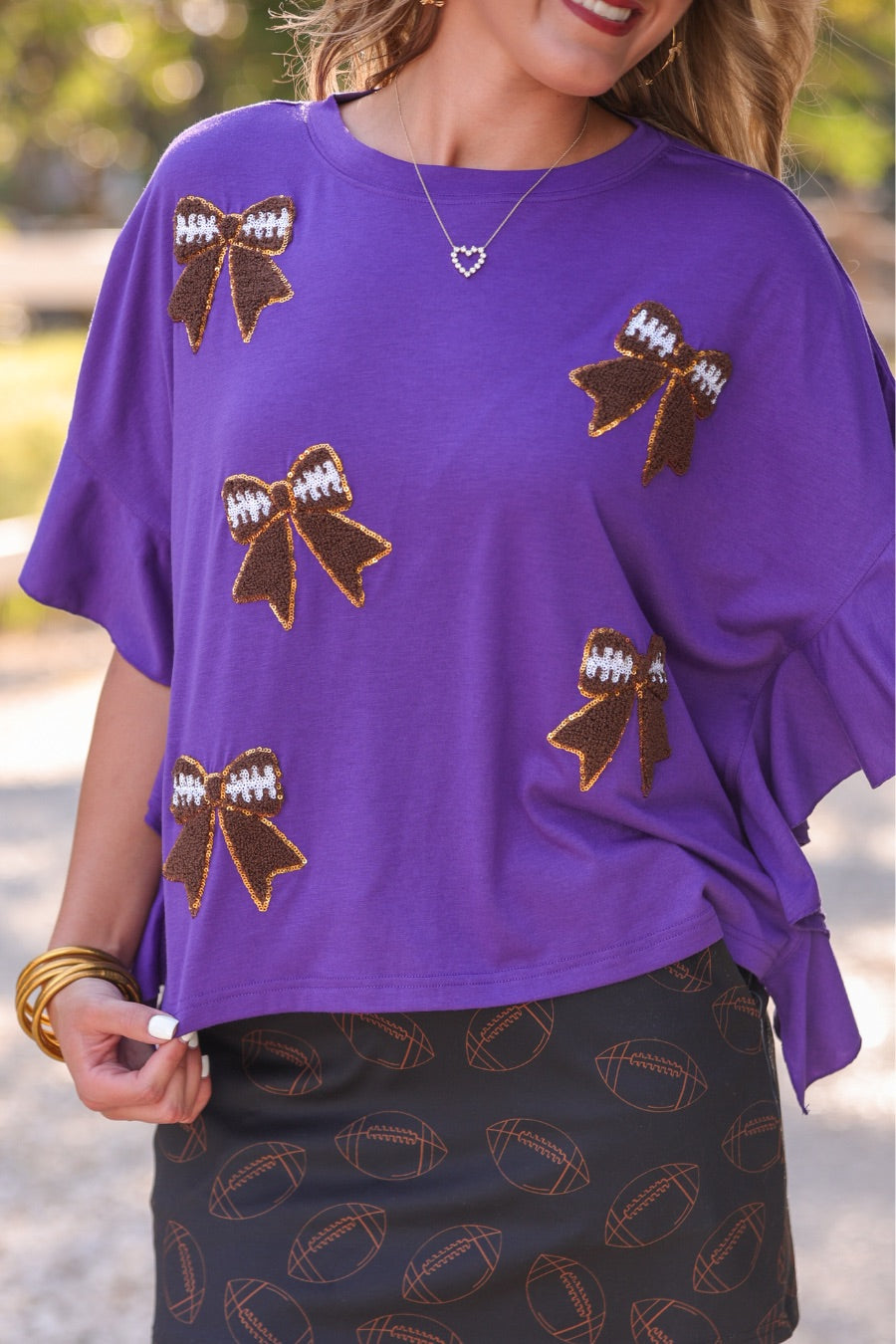 mid-rise relaxed fit everyday skort made of lightweight material with built-in cream shorts, drawstring tie with gold bead accents, an elastic band on the back, and side pockets, designed on an all-over football outline pattern print fabric in black