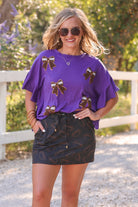 mid-rise relaxed fit everyday skort made of lightweight material with built-in cream shorts, drawstring tie with gold bead accents, an elastic band on the back, and side pockets, designed on an all-over football outline pattern print fabric in black