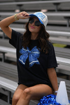 a black Comfort Colors tee crafted on soft garment-dyed cotton with a DTF-printed blue faux glitter football bow graphic, crew neckline, and short sleeves in both youth and adult sizing