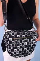 spacious bum bag with double front zippers, a back zipper, an interior zipper pocket, an adjustable strap, and gold hardware accents in bow chic checkered