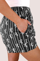 mid-rise relaxed fit boxer shorts with side pockets and an elastic waistband, designed on a bow and stripe pattern print and a solid base in black