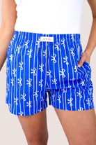 mid-rise relaxed fit boxer shorts with side pockets and an elastic waistband, designed on a bow and stripe pattern print and a solid base in blue