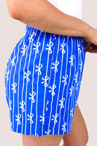 mid-rise relaxed fit boxer shorts with side pockets and an elastic waistband, designed on a bow and stripe pattern print and a solid base in blue